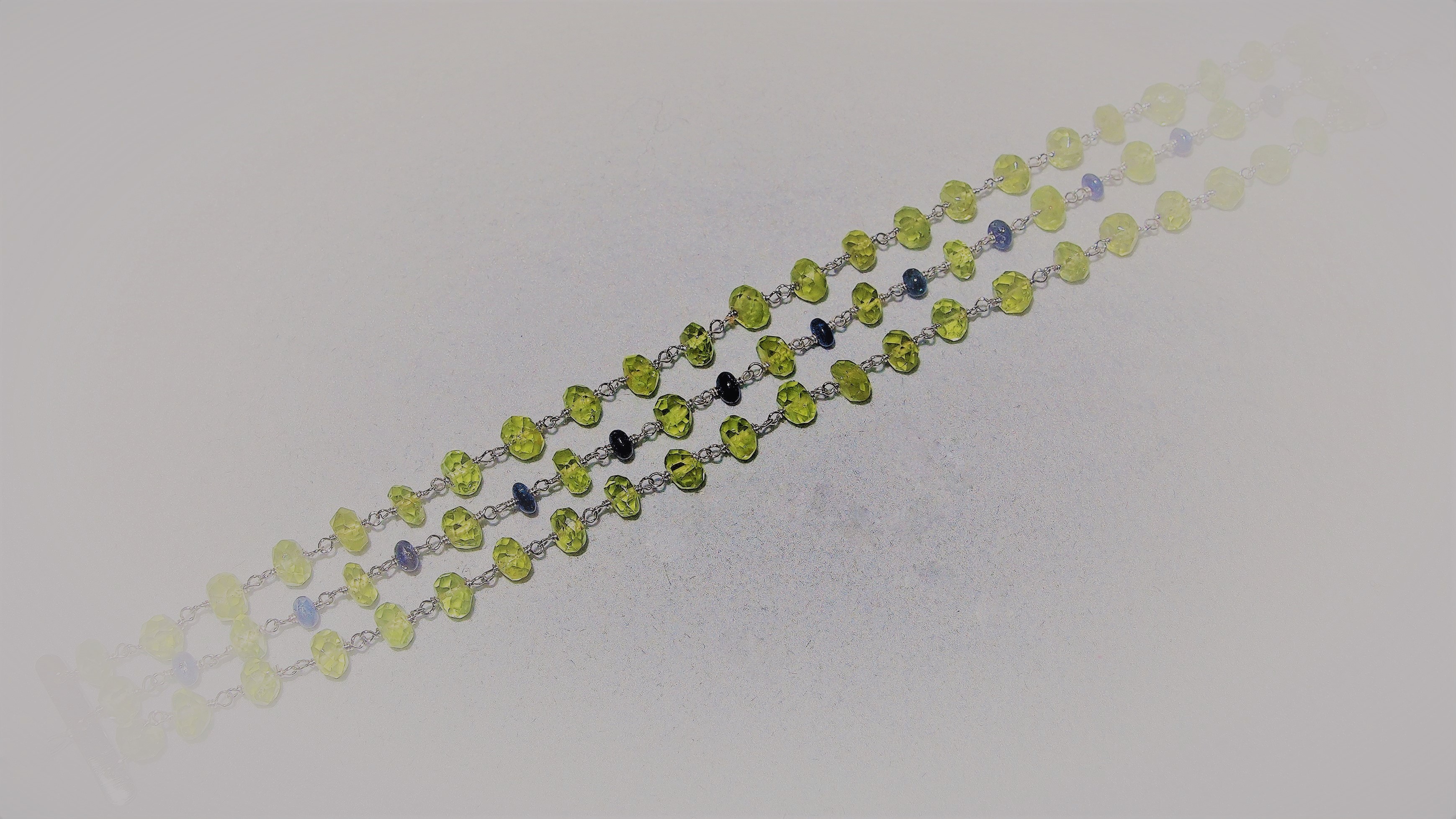 Bracciale in Oro 750 millesimi con Peridoti e Zaffiri naturali  tagliati a rondelle sfaccettate.